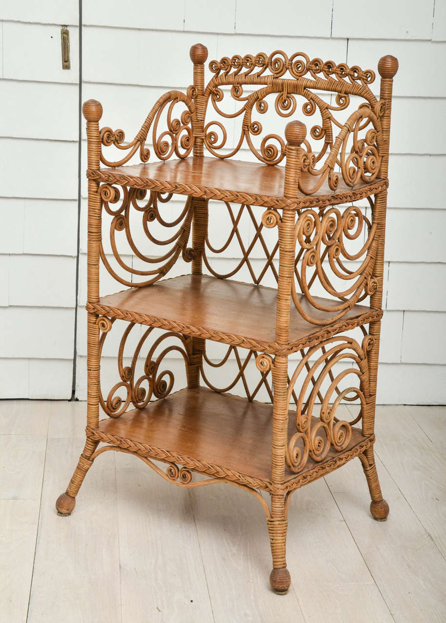 Etagere with three wood shelves supported by curvilinear back and sides; on splayed legs.